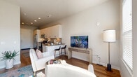 Located at 1701 Central Ave. in the heart of St. Petersburg, FL, this thoughtfully designed single-floor unit makes excellent use of its compact footprint. The open layout connects the living and sleeping areas seamlessly, with warm-toned hardwood-style flooring running throughout to create a cohesive, inviting atmosphere.

The kitchen is a standout feature, outfitted with sleek white cabinetry extending to the ceiling for generous storage, dark charcoal countertops, a tile backsplash, and a full suite of stainless steel appliances including a refrigerator, range, microwave, and dishwasher. A deep undermount sink completes the functional workspace.

The living and sleeping area is bright and open, benefiting from a ceiling fan and access to natural light through large windows and a glass door that opens to an outdoor space. The clean white walls provide a versatile backdrop for personalization.

The bathroom is well-appointed with a combined tub and shower enclosed by a full tile surround and curtain, a dark-countered vanity with ample cabinetry, and light wood-style flooring. A dedicated closet provides additional storage, and a stacked in-unit washer and dryer adds everyday convenience. This unit offers a modern, efficient living experience in a prime Central Avenue location.