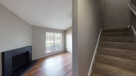 This two-story residence in Houston, Texas offers a functional and well-organized layout spread across two levels. The main floor features rich hardwood flooring throughout, anchored by a brick fireplace in the living area, which also benefits from a large window fitted with horizontal blinds that allows natural light to fill the space. The entry area opens to the living room, with a carpeted staircase leading to the upper level.

The galley-style kitchen is efficiently designed with gray cabinetry on both sides, speckled countertops, a double-basin sink, and black appliances including a range and refrigerator. Hardwood flooring continues through the kitchen, reinforcing a cohesive aesthetic on the main level. An additional room on the main floor, illuminated by recessed lighting, provides flexible use.

Upstairs, both bedrooms are finished with plush carpeting and feature ceiling fans. Each room receives natural light through blinds-equipped windows. Both bathrooms are consistent in design, each offering a vanity with speckled countertops, an undermount sink, and a tub-shower combination. Neutral gray tones are carried throughout the home, creating a clean, understated atmosphere.