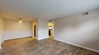 Located at 149 Olde English Ct in Louisville, Kentucky, this single-floor unit offers a practical and well-organized layout designed for comfortable everyday living. The open living area is finished with durable wood-look flooring and neutral-toned walls, creating a bright and welcoming atmosphere. Natural light filters in through windows fitted with horizontal blinds, and a textured ceiling adds a classic finishing touch throughout the main areas. The living space connects directly to a dedicated kitchen, which features warm honey-toned cabinetry, light countertops, a double-basin sink, a black electric range, and a dishwasher — providing ample storage and functionality for meal preparation. The bedrooms are carpeted for added comfort and each includes windows that bring in natural light, contributing to a calm and restful environment. The unit includes two bathrooms: a full bath with a tub-shower combination, a wood-vanity with a white countertop, and wood-look flooring; and a second bathroom with a separate toilet room, a similarly styled vanity, and matching flooring. Clean white trim and baseboards are consistent throughout the unit, tying the overall design together with a cohesive, tidy aesthetic.