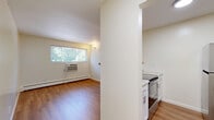 Located at 3619 Clarion Ave in Cincinnati's 45207 zip code, this one-bedroom, one-bathroom unit offers a well-organized, single-floor layout designed for comfortable everyday living. Warm hardwood-style flooring runs throughout, creating a cohesive and inviting atmosphere across all rooms.

The kitchen features white shaker-style cabinetry, a stainless steel refrigerator, and a raised wood-top bar counter that opens to the living area, providing both additional prep space and a casual dining surface. Recessed lighting keeps the kitchen bright and functional.

The bedroom is generously sized, offering ample room for furnishings. A ceiling fan with integrated lighting provides both comfort and illumination, while a large window invites natural light and views of mature greenery outside. A baseboard heating unit ensures warmth during cooler months.

The bathroom is finished with classic white subway tile along the lower walls, a combined tub and shower, a vanity, and hardwood-style flooring that ties in with the rest of the unit. The clean, neutral palette gives the space a bright, well-maintained feel.

A dedicated closet provides convenient storage. The unit's efficient, thoughtfully arranged floor plan makes excellent use of its footprint, delivering a practical and comfortable living environment.