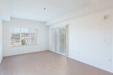 Located at 3115 Finnian Way in Dublin, California, this 2-bedroom, 2-bathroom residence offers a well-organized single-level layout designed for comfortable everyday living. The entrance opens into a combined living and dining area bathed in natural light from large windows, with light-toned laminate flooring that extends throughout the main living spaces. The open kitchen features warm wood-toned cabinetry, a peninsula with a breakfast bar, a double-basin sink, and white appliances including a refrigerator, gas range, and microwave. Track lighting overhead adds a modern functional touch. The primary bedroom is generously proportioned, carpeted for comfort, and includes access to natural light through a large window. The second bedroom is also carpeted and offers its own closet. Both bathrooms are finished with light wood vanities, light flooring, and include accessibility grab bars — one bathroom features a tub/shower combination with a handheld showerhead. A dedicated laundry area and three closets provide substantial storage throughout. Sliding glass doors lead to a private balcony with views of the surrounding Dublin neighborhood. The overall aesthetic is clean, neutral, and move-in ready.