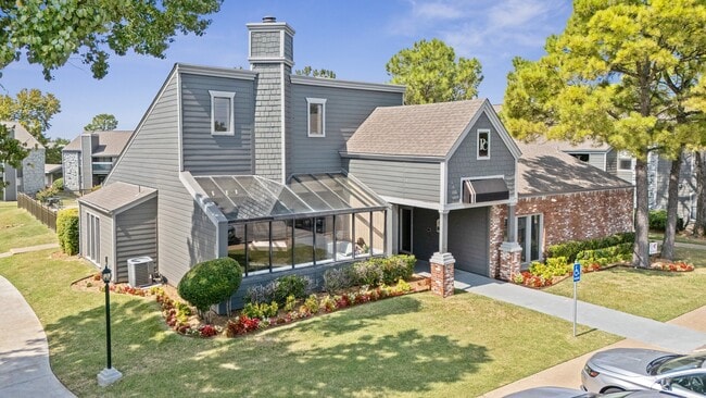 Charming leasing office exterior with glass sunroom, manicured landscaping, and accessible walkway - Polo Club Apartments