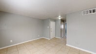 Located at 3737 Hillcroft St in Houston, Texas, this one-bedroom, one-bathroom unit offers a functional single-floor layout designed for comfortable everyday living. Light gray walls and consistent large-format tile flooring run throughout the space, creating a clean, cohesive aesthetic.

The living room is generously sized and filled with natural light from a sliding glass door that opens to the outdoors, as well as a window fitted with blinds. The open feel of this area makes it a versatile and welcoming main living space.

The galley-style kitchen features white cabinetry with gold hardware, white countertops, and tile flooring, with room for a full-size refrigerator and dishwasher. The efficient layout maximizes storage and workspace within the compact footprint.

The bedroom is a well-proportioned retreat, brightened by a window with blinds and equipped with two separate closets — offering notable storage flexibility. A flush-mount light fixture and textured ceiling add to the room's practical character.

The bathroom maintains the home's clean white palette, with a vanity cabinet featuring matching gold hardware, an over-toilet storage cabinet, and tile flooring throughout. The layout is efficient and well-organized. Overall, this unit presents a neat, move-in-ready space in a convenient Houston location.