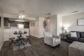 Located at 16950 Jasmine St in Victorville, California, this single-floor unit offers a well-organized, open-concept layout designed for comfortable everyday living. The main living area is spacious and inviting, featuring warm wood-style flooring, a ceiling fan, and a textured ceiling that extends throughout the common spaces. The living room flows naturally into the dining area, creating a cohesive entertaining space with room for both seating and a dining set.

The kitchen is functionally designed with rich dark cabinetry, white appliances including a gas range, over-the-range microwave, dishwasher, and refrigerator, complemented by light countertops and a double-basin sink. The layout maximizes efficiency and storage within a compact footprint.

The bedroom is a well-sized, carpeted retreat featuring a sliding glass door that leads to an outdoor area, allowing for natural light and exterior access. Vertical blinds provide privacy and light control.

The bathroom is neatly appointed with a tub-shower combination, wood-style flooring, a vanity with storage, and clean white tile surround. The warm, neutral color palette carried throughout the unit creates a cohesive and welcoming atmosphere, making this a practical and comfortable single-level residence in the high desert community of Victorville.