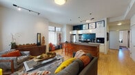 Located at 1589 E 118th St in Cleveland, OH, this single-floor residence offers a thoughtfully designed open-concept layout that seamlessly connects the living, dining, and kitchen areas. The living room is bright and inviting, with large windows fitted with blinds that allow generous natural light to fill the space. Track lighting runs along the ceiling, complementing warm hardwood flooring and creating a modern yet comfortable ambiance.

The kitchen is a standout feature, showcasing white cabinetry paired with a bold teal accent wall, dark countertops, and stainless steel appliances including a refrigerator and electric range. A wood-paneled island with bar seating adds both function and style, with pendant lights hanging above for focused illumination.

The bedroom is well-proportioned, featuring plush carpeting, tall windows that bring in ample daylight, and built-in closet storage. Its clean, neutral palette creates a calm and restful environment.

The bathroom is elegantly finished with tile flooring, a dark floating vanity, tall windows that enhance the sense of openness, and a glass-enclosed shower. Throughout the residence, the design reflects a contemporary aesthetic with vibrant accent colors and cohesive, modern finishes.