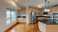 This single-floor residence offers a well-designed layout across two bedrooms and two bathrooms. The open-concept living area is a standout feature, showcasing gleaming hardwood floors that extend throughout the main living spaces. A fireplace with a sleek dark surround serves as a focal point, while recessed lighting and large windows provide ample natural light. Sliding glass doors lead to an outdoor area, enhancing the sense of openness.

The kitchen is thoughtfully equipped with light maple cabinetry, dark granite countertops, and a full suite of stainless steel appliances, including a French door refrigerator, double wall oven, built-in microwave, and dishwasher. A center island with matching granite provides additional prep and dining space, while pendant lighting adds a refined touch.

Both bathrooms feature tile flooring and light maple cabinetry with granite countertops. The primary bathroom includes a tall storage cabinet and a large vanity mirror, while the secondary bathroom offers a glass-enclosed shower and built-in shelving for storage.

A dedicated laundry room houses a full-size washer and dryer alongside a utility sink and shelving, adding practical convenience to this well-appointed residence.