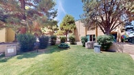 Located at 7834 Viscount Blvd in El Paso, Texas, this outdoor communal space offers a welcoming and well-kept environment designed for gathering and relaxation. The grounds are characterized by expansive, neatly maintained green lawns that provide an open and inviting atmosphere under the clear West Texas sky.

Towering mature pine and deciduous trees are distributed throughout the courtyard, offering natural shade and a sense of established character to the landscape. Manicured shrubs and ornamental plantings are thoughtfully arranged throughout the space, adding visual interest and definition to various areas.

The grounds include multiple green picnic tables and benches, providing dedicated spots for outdoor dining and socializing. Raised brick planters and low brick walls serve as functional architectural accents, dividing and organizing the outdoor areas with a cohesive design aesthetic.

Wide concrete walkways connect different sections of the grounds, ensuring easy and accessible movement throughout the space. A built-in brick barbecue structure is also present, further enhancing the space's suitability for communal outdoor activities.

The surrounding multi-story buildings, clad in warm tan brick with teal accent trim and staircase railings, frame the courtyard and contribute to the cohesive visual character of the property. Overall, the space presents a functional and pleasant outdoor environment well-suited for community use.