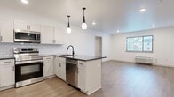 Located at 458 Parker Ave in Philadelphia's Roxborough neighborhood, this thoughtfully designed 2-bedroom, 2-bathroom unit offers a clean, modern aesthetic throughout. The open-concept kitchen and living area serves as the heart of the space, anchored by a central island with dark countertops, a stainless steel sink with a matte black faucet, and built-in dishwasher. White shaker cabinetry, a classic subway tile backsplash, and stainless steel appliances — including a range, microwave, and refrigerator — complete the kitchen. Stylish dual pendant lights hang above the island, adding a contemporary touch. The living area flows seamlessly from the kitchen, featuring warm wood-look flooring and natural light from a window overlooking the exterior. Both bedrooms are well-proportioned, with the primary offering a comfortable footprint, wood-look flooring, a window, and a wall-unit HVAC system. The second bedroom is a versatile space with clean white walls and the same consistent flooring. Two closets provide ample storage. The bathrooms feature hexagonal tile surrounds on the tub/shower, lending a modern yet timeless design. Recessed lighting and a neutral color palette unify the space with a bright, contemporary feel.