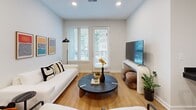 Located at 1414 4th Avenue South in Nashville, TN, this thoughtfully designed one-bedroom, one-bathroom residence offers a modern aesthetic throughout its efficiently laid-out single floor. The open-concept great room seamlessly integrates the kitchen, dining, and living areas, creating a bright and connected living space bathed in natural light from large windows and a balcony door. The kitchen is a standout feature, boasting dark lower cabinetry contrasted by warm wood upper cabinets, dark tile backsplash, granite countertops, stainless steel appliances, and ample storage. The living area offers direct access to a private balcony, extending the living space outdoors. The bedroom is a well-proportioned retreat carpeted for comfort, with large windows that bring in natural light and views of the surrounding cityscape. The bathroom features clean white subway tile surrounding a full soaking tub and shower combination, dark fixtures, and a dark-cabinetry vanity with a white countertop. Additional highlights include two closets, a dedicated laundry area, a utility room, and wood-look flooring throughout the main living areas, all contributing to a clean, contemporary feel.
