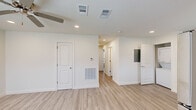 This single-story, two-bedroom, two-bathroom unit in Houma, Louisiana, presents a clean, modern interior defined by a consistent light wood-look vinyl plank flooring that runs throughout the space. The open layout connects the main living area to a well-appointed kitchen, which features gray shaker-style cabinetry, white countertops, and a full suite of stainless steel appliances including a range, microwave, dishwasher, and refrigerator. A dedicated in-unit stacked washer and dryer is conveniently tucked into a closet just off the kitchen. Recessed lighting and ceiling-mounted HVAC vents provide a tidy, streamlined look overhead, while a thermostat is centrally positioned in the main living area for easy access.

Both bedrooms are generously proportioned, each equipped with a ceiling fan with light kit and a window fitted with blinds that allow for natural light and privacy. The two bathrooms mirror each other in design, each offering a full tub-shower combination with brushed nickel fixtures and white surrounds. One bathroom includes a gray vanity with an undermount sink, white countertop, and a mirror, adding a refined touch. The overall aesthetic is fresh, neutral, and move-in ready.