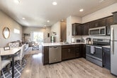 Located at 117 Harvey Dr in Waterloo, Iowa, this three-bedroom, four-bathroom home spans three floors, offering a well-organized and functional layout. The main living level features an open-concept kitchen and living room with light hardwood-style flooring, recessed lighting, and a sliding glass door that opens to an outdoor deck. The kitchen is equipped with stainless steel appliances, dark espresso cabinetry, a white countertop peninsula with a built-in sink, and ample storage. The living area is bright and airy, benefiting from natural light and views to the exterior. Each of the three bedrooms is carpeted and includes windows for natural light and closet space, with the primary bedroom offering a dedicated closet and a comfortable, neutral palette. The four bathrooms are clean and modern, featuring tile flooring, dark vanity cabinetry with white countertops, and tiled shower enclosures. A second living room or flex space on a lower floor provides additional room for relaxation or entertaining. The home also includes a laundry room, utility room, hallway, and an attached garage with drywall-finished walls. With four closets and thoughtful storage throughout, this multi-level home offers practical living across every floor.