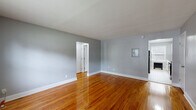 Located at 36 Welcher Avenue in Peekskill, NY, this well-appointed one-bedroom, one-bathroom unit offers a thoughtfully designed single-floor layout. Rich, gleaming hardwood floors flow throughout the living areas and bedroom, lending warmth and continuity to the space.

The living room is generously proportioned, bathed in natural light from large windows, and features a baseboard heating unit and access to multiple doorways that connect the home's key areas. Neutral gray walls complement the warm tones of the flooring throughout.

The bedroom is a comfortable retreat, featuring a ceiling fan, a natural-light-filled window with an outdoor view, and a radiator. Four closets distributed throughout the unit provide exceptional storage capacity rarely found in similarly sized homes.

The kitchen is bright and modern, outfitted with white shaker-style cabinetry, marble-look countertops, a subway tile backsplash, and stainless steel appliances including a gas range, built-in microwave, dishwasher, and refrigerator. Light tile flooring and a window overlooking greenery complete the space.

The bathroom is clean and stylish, featuring a tiled tub-shower combination with a decorative mosaic accent border, a white vanity with a marble-look countertop, and light tile flooring.