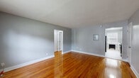 Located at 36 Welcher Avenue in Peekskill, NY, this well-appointed one-bedroom, one-bathroom unit offers a thoughtfully designed single-floor layout. Rich, gleaming hardwood floors flow throughout the living areas and bedroom, lending warmth and continuity to the space.

The living room is generously proportioned, bathed in natural light from large windows, and features a baseboard heating unit and access to multiple doorways that connect the home's key areas. Neutral gray walls complement the warm tones of the flooring throughout.

The bedroom is a comfortable retreat, featuring a ceiling fan, a natural-light-filled window with an outdoor view, and a radiator. Four closets distributed throughout the unit provide exceptional storage capacity rarely found in similarly sized homes.

The kitchen is bright and modern, outfitted with white shaker-style cabinetry, marble-look countertops, a subway tile backsplash, and stainless steel appliances including a gas range, built-in microwave, dishwasher, and refrigerator. Light tile flooring and a window overlooking greenery complete the space.

The bathroom is clean and stylish, featuring a tiled tub-shower combination with a decorative mosaic accent border, a white vanity with a marble-look countertop, and light tile flooring.