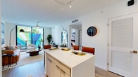 Located at 45 NE 27th St in Miami's vibrant Edgewater neighborhood, this thoughtfully designed two-bedroom, two-bathroom residence offers a clean, modern aesthetic throughout. The open-concept living and dining area flows seamlessly from the well-appointed kitchen, which features a large center island with bar seating, sleek gray flat-panel cabinetry, stainless steel appliances, a textured tile backsplash, and quartz countertops. Track lighting and wood-look flooring run throughout, lending warmth and continuity to the space. Floor-to-ceiling windows and a private balcony flood the interior with natural light and offer views of a colorful exterior mural and the surrounding building courtyard. The primary bedroom is a comfortable retreat, highlighted by large windows, a ceiling fan, and generous closet storage. The second bedroom is equally well-lit and appointed. Both bathrooms are finished with clean white cabinetry, quartz vanities, and neutral tile. The residence includes five closets, providing ample storage throughout. The hallway connects the living spaces efficiently, completing a well-organized floor plan ideal for Miami living.