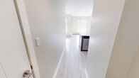 Located on the 5th floor at 1218 12th Ave SW in Calgary, Alberta, this one-bedroom, one-bathroom unit offers a clean, modern design with a highly functional layout. Light hardwood-style flooring runs throughout the main living areas, complemented by crisp white walls and abundant natural light that flows in through large windows.

The kitchen is a standout feature, showcasing warm wood-toned cabinetry, white quartz countertops, a subway tile backsplash, and a full suite of stainless steel appliances including a refrigerator, electric range, over-the-range microwave, and dishwasher. A peninsula counter provides additional prep space and opens seamlessly to the living area, enhancing the open feel of the unit.

The bedroom is a comfortable retreat with large windows framing urban Calgary views, and baseboard heating ensures year-round comfort. The neutral warm-beige tones create a calm, inviting atmosphere.

The bathroom is well-finished with tile flooring, a combined tub-shower, and a wood-panel vanity with a white countertop. The entrance hallway offers a practical transition into the main living space.

Overall, this unit presents a bright, contemporary living environment with modern finishes and a thoughtfully efficient floor plan, ideally situated in Calgary's vibrant southwest.