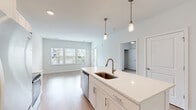 Located at 44000 Owl Wood Lane in Summerville, SC, this one-bedroom, one-bathroom residence offers a thoughtfully designed single-floor layout with a clean, modern aesthetic throughout. The open-concept living and kitchen area serves as the heart of the home, featuring light wood-style flooring, soft neutral wall tones, and an abundance of natural light streaming through large windows. The kitchen is well-appointed with white shaker cabinetry, light quartz countertops, a central island with an undermount bronze-finish sink, stylish pendant lighting with brass hardware, and a full suite of stainless steel appliances including a refrigerator, electric range, and built-in microwave. The living area flows seamlessly from the kitchen, offering a bright and open feel. The bedroom is carpeted for comfort, includes a ceiling fan, and is generously sized with windows that bring in natural light and views of the surrounding greenery. A dedicated closet provides organized storage. The bathroom features a tub-shower combination with white subway tile surround, wood-style flooring, a white vanity, and recessed lighting, with convenient access to the closet area. The overall design is cohesive, clean, and move-in ready, making this residence a practical and attractive living space.