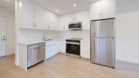 Located at 46120 Thomas Rd in Chilliwack, BC, this thoughtfully designed 2-bedroom, 1-bathroom unit offers a modern and functional layout across a single floor. The space features two fully equipped kitchens, each outfitted with sleek white cabinetry, light quartz countertops, subway tile backsplashes, and stainless steel appliances including a dishwasher, range, microwave, and refrigerator. Light wood laminate flooring runs throughout the main living areas and bedrooms, lending warmth and continuity to the clean, contemporary aesthetic. The bedrooms are bright and practical, with crisp white walls and natural light provided by well-placed windows that frame views of the surrounding neighbourhood and lush greenery. The primary bedroom includes a sliding door closet for efficient storage. The full bathroom is finished in a neutral palette, featuring a combined tub and shower with a chrome handheld showerhead and tile surround. Recessed lighting and white trim throughout the unit contribute to a fresh, modern ambiance. The overall design prioritizes simplicity and functionality, making this a versatile and well-appointed space in the Sardis area of Chilliwack.