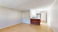 Located on the iconic Rue Crescent in downtown Montréal, this 3-bedroom, 1-bathroom unit offers a functional and well-appointed layout throughout a single floor. Classic parquet flooring runs consistently throughout the living areas and bedrooms, lending warmth and character to the space.

The open living area is bright and airy, anchored by large windows with baseboard heating beneath and views of the surrounding Montréal cityscape. The kitchen features a striking two-tone design with rich wood lower cabinetry contrasted by crisp white upper cabinets and countertops. Stainless steel appliances, including a refrigerator and electric range, complement the modern aesthetic, while a peninsula with a matching wood facade creates a natural division between the kitchen and living area.

Each bedroom is comfortably sized with parquet flooring, crown moulding, and ample natural light. The primary bedroom features large windows framing panoramic city skyline views, and several bedrooms include built-in closets with panelled doors for added storage. The bathroom is finished with large-format travertine-style tile in the tub surround and flooring, paired with a white vanity and clean, neutral walls. The overall ambiance is clean, neutral, and move-in ready.