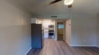 This single-story 1-bedroom, 1-bathroom residence in Phoenix, AZ offers a functional and modern living experience. The open layout connects the living area to the kitchen, creating a cohesive and practical flow throughout the space. Wood-look plank flooring extends across the main living areas, providing a clean and contemporary aesthetic, while textured ceilings and ceiling fans add character and comfort.

The kitchen is a standout feature, outfitted with a full suite of stainless steel appliances including a refrigerator, gas range, microwave, and dishwasher. White shaker-style cabinetry with brushed nickel hardware pairs elegantly with a classic white subway tile backsplash and light-toned countertops, creating a bright and inviting workspace. A stainless steel sink with a modern pull-down faucet completes the well-designed kitchen.

The living room is generously sized, receiving natural light through a window that offers a view of the surrounding outdoor area. A ceiling fan provides year-round comfort. The bedroom continues the wood-look flooring and benefits from natural light through a window.

The bathroom features a tiled tub-and-shower combination with neutral beige tile surround, a toilet, and a clean, functional layout. This residence offers a practical and attractive option for those seeking comfortable living in the Phoenix area.
