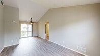 Located at 1750 Melville Dr in Rochester Hills, MI, this two-bedroom, two-bathroom two-story home offers a well-designed layout across two levels. The main living level is where the majority of the space is found, beginning with an inviting entrance that leads upstairs via carpeted staircases with clean white railings. The living room is a standout space, boasting dramatic vaulted ceilings, a ceiling fan, and light hardwood-style flooring. Sliding glass doors open to a private balcony, flooding the room with natural light and providing outdoor views. The adjacent dining area continues the open, airy feel with large windows and pendant lighting above. The kitchen is well-appointed with rich dark wood cabinetry, light countertops, stainless steel appliances including a refrigerator, range, and microwave, and a double stainless steel sink beneath a window. Both bedrooms feature plush carpeting; the primary bedroom includes its own closet, while the second bedroom offers a window with leafy outdoor views. Two full bathrooms include vanities with wood cabinetry and tub-shower combinations. Additional highlights include five closets for ample storage, a dedicated laundry area, a pantry, and two hallways connecting the thoughtfully arranged rooms throughout the home.