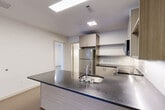 Located at 400 Langley Rd in Newton, MA, this well-appointed 2-bedroom, 2-bathroom residence offers a thoughtfully designed single-level layout with a clean, contemporary aesthetic throughout. The open-concept living area seamlessly connects the kitchen, dining, and living spaces, creating a bright and functional hub for daily life. The modern kitchen is a standout feature, boasting a large island with a dark stone countertop and integrated sink, light wood-grain cabinetry, open shelving, a white subway tile backsplash, and stainless steel appliances including a refrigerator, range, and over-the-range microwave. Warm hardwood-style flooring flows through the main living areas, while the living room benefits from generous natural light and direct access to a private outdoor deck. Both bedrooms are well-proportioned, with the primary bedroom offering a dedicated closet and easy access to its own bathroom. The bathrooms are finished with large-format tile flooring, wood-tone vanities, dark stone countertops, and mirrored medicine cabinets. Additional highlights include four closets for abundant storage and a dedicated in-unit laundry area, rounding out this practical and stylish residence.