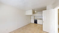 Located in Phoenix, Arizona, this efficiently designed one-bedroom, one-bathroom unit offers a practical and functional layout across a single floor. Light-toned ceramic tile flooring runs throughout the entire space, creating a cohesive and easy-to-maintain interior.

The open-plan kitchen and living area serves as the heart of the unit. The kitchen is equipped with white cabinetry providing ample storage, a white electric range, a full-size refrigerator, a dishwasher, and a double basin sink with overhead cabinets. A dedicated pantry offers additional storage conveniently adjacent to the kitchen.

The bedroom receives generous natural light through a window fitted with blinds and includes a wall-mounted air conditioning unit for climate control. A closet provides dedicated storage within the room, and a textured ceiling is consistent throughout the unit.

The bathroom features a full tub-and-shower combination with white tiled surround, a toilet, and a vanity with wooden cabinetry and countertop. The tile flooring continues seamlessly into this space.

Overall, the unit presents a clean, neutral palette with white walls and textured ceilings, creating a bright and functional living environment well-suited for those seeking a straightforward, no-frills residence in Phoenix.