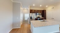 Located on 160th Street West in Lakeville, Minnesota, this two-story home offers a well-designed layout with thoughtful finishes throughout. The main level showcases an open-concept living and kitchen area finished with light hardwood-style flooring and recessed lighting. The kitchen is equipped with rich dark cabinetry, granite countertops, a center island with a built-in sink, and a full suite of stainless steel appliances including a refrigerator, electric range, and over-the-range microwave. Crown molding adds a refined touch to the main living space, which flows toward a sliding glass door that opens onto a private balcony with outdoor views.

The upper level features carpeted bedrooms that provide a comfortable, quiet retreat, with windows that bring in natural light and views of the surrounding landscape. A walk-in closet with wire shelving offers generous storage. The bathroom includes dark vanity cabinetry and granite countertops consistent with the home's overall aesthetic.

The attached garage features drywall-finished walls, a concrete floor, and an automatic opener, providing practical everyday convenience. A carpeted staircase with a wood handrail connects the two floors seamlessly.