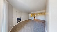 Located at 6570 W Flamingo Rd in Las Vegas, NV, this 2-bedroom, 2-bathroom residence offers a practical and comfortable single-floor layout. The open living room is a welcoming centerpiece, featuring plush carpet, neutral tones, and a corner fireplace framed by a clean white surround. Sliding glass doors lead to a private balcony, filling the space with natural light and outdoor views. The kitchen flows seamlessly from the living area via a pass-through counter, showcasing white shaker cabinetry, dark granite countertops, light wood-style flooring, recessed lighting, and a full suite of stainless steel appliances including a gas range, microwave, and refrigerator. Both bedrooms are carpeted and outfitted with ceiling fans; the primary bedroom includes a dedicated closet and adjoining bathroom with a granite-topped vanity, white cabinetry, and a soaking tub. The second bathroom mirrors this finish with matching granite counters, white cabinetry, and a tub-shower combo. Two closets provide ample storage throughout. The unit's consistent use of neutral walls, wood-style flooring in wet areas, and updated fixtures creates a cohesive, move-in-ready aesthetic.