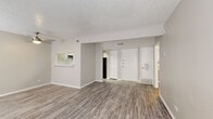 Located at 7543 S Sea Ln in San Antonio, Texas, this single-floor residence offers a clean, updated interior with a neutral color palette throughout. The open living area is finished with durable wood-look luxury vinyl plank flooring and features a textured ceiling, a ceiling fan with light fixture, and a pass-through window connecting to the kitchen, creating an airy, connected feel. A closet and front entry door are conveniently positioned off the main living space.

The kitchen is well-appointed with light gray cabinetry, white quartz-style countertops, a classic white subway tile backsplash, a stainless steel sink with a modern gooseneck faucet, a gas range, and a black refrigerator. The layout is efficient and functional, complemented by the same wood-look flooring found throughout the main areas.

A spacious bedroom features plush carpeting, a ceiling fan, a window with blinds allowing natural light, and ample room for furnishings. An additional room with dual windows provides flexible living or sleeping space, also finished with wood-look flooring and a textured ceiling.

The bathroom includes a wide vanity with gray cabinetry, a large mirror, and a well-lit Hollywood-style light bar above the sink. The overall design is cohesive, modern, and move-in ready.