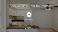 This single-floor residence offers a practical and functional layout across two bedrooms, one kitchen, a hallway, and a dedicated closet. The open-concept kitchen serves as a central feature of the living area, equipped with white cabinetry, dark countertops, a gas range, a full-size refrigerator, and a double-basin sink integrated into a peninsula breakfast bar that separates the kitchen from the living space. A raised tray ceiling with a flush-mount light fixture adds architectural interest to the kitchen area, while light wood-style flooring extends through the main living and kitchen zones. A ceiling fan with a light kit is positioned in the living area, contributing to airflow and functionality.

Both bedrooms are carpeted and receive natural light through horizontal windows fitted with vertical blinds. The primary bedroom features full-width mirrored sliding closet doors, enhancing the sense of space. The secondary bedroom is more compact, offering a quiet, neutral retreat. A dedicated walk-in closet provides built-in shelving along the walls, maximizing storage capacity. Neutral-toned walls and textured ceilings are consistent throughout, creating a cohesive, understated aesthetic across the entire unit.
