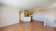 Located at 20455 Sorrento Lane in Los Angeles, CA, this well-appointed 2-bedroom, 2-bathroom single-floor residence offers a functional and comfortable layout. The open-concept living and kitchen area anchors the home, featuring warm hardwood-style flooring throughout, recessed lighting, and a ceiling fan. The kitchen is equipped with honey-toned wood cabinetry, granite-style countertops, stainless steel appliances including a gas range, microwave, and dishwasher, and a peninsula that provides additional counter space and separates the kitchen from the living area. The living room offers access to an outdoor space through full sliding glass doors dressed with vertical blinds, filling the area with natural light. The spacious primary bedroom features plush carpeting, multiple windows with neighborhood views, and generous closet space. The second bedroom is similarly well-lit with large windows and carpet flooring, complemented by a walk-in closet with built-in shelving. Both bathrooms are clean and practical, with one featuring a tub-shower combination with sliding glass doors and wood-toned vanity cabinetry. A hallway connects the living spaces to the bedrooms and bathrooms, providing a well-organized flow throughout the home.