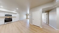 Located at 651 McKnight St in Las Vegas, NV, this single-story 2-bedroom, 1-bathroom unit offers a well-designed, functional layout with a clean, modern aesthetic. Light wood-style flooring runs throughout the entire space, creating a cohesive and contemporary feel.

The open kitchen is a standout feature, equipped with a full suite of stainless steel appliances — including a refrigerator, range, over-the-range microwave, and dishwasher — paired with crisp white cabinetry that extends to the ceiling for ample storage, and light countertops illuminated by recessed ceiling lights.

The living area flows naturally from the kitchen, offering an open and versatile space. Both bedrooms are comfortably sized, featuring neutral warm-toned walls, ceiling fans, and windows fitted with blinds that bring in natural light. The primary bedroom includes a sliding double-door closet for generous storage. A second bedroom provides equally functional space with clean, light-filled interiors.

The bathroom is thoughtfully appointed with accessibility features, including grab bars near the toilet and an open walk-in shower with built-in shelving. The vanity offers additional storage and counter space.

Throughout, the unit presents a bright, move-in-ready interior with a consistent neutral palette, clean lines, and practical finishes suited for comfortable everyday living in Las Vegas.