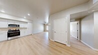 Located at 651 McKnight St in Las Vegas, NV, this single-story 2-bedroom, 1-bathroom unit offers a well-designed, functional layout with a clean, modern aesthetic. Light wood-style flooring runs throughout the entire space, creating a cohesive and contemporary feel.

The open kitchen is a standout feature, equipped with a full suite of stainless steel appliances — including a refrigerator, range, over-the-range microwave, and dishwasher — paired with crisp white cabinetry that extends to the ceiling for ample storage, and light countertops illuminated by recessed ceiling lights.

The living area flows naturally from the kitchen, offering an open and versatile space. Both bedrooms are comfortably sized, featuring neutral warm-toned walls, ceiling fans, and windows fitted with blinds that bring in natural light. The primary bedroom includes a sliding double-door closet for generous storage. A second bedroom provides equally functional space with clean, light-filled interiors.

The bathroom is thoughtfully appointed with accessibility features, including grab bars near the toilet and an open walk-in shower with built-in shelving. The vanity offers additional storage and counter space.

Throughout, the unit presents a bright, move-in-ready interior with a consistent neutral palette, clean lines, and practical finishes suited for comfortable everyday living in Las Vegas.