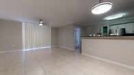 Located at 353 Aragon Ave in the heart of Coral Gables, Florida, this single-floor suite offers a well-organized layout with distinct living, sleeping, and kitchen zones. The open living and dining area features large-format light tile flooring, crown molding, and a ceiling fan, with vertical blinds covering expansive windows that allow natural light to filter through.

The kitchen is thoughtfully designed with white cabinetry, dark granite countertops, a mosaic tile backsplash, and a full suite of stainless steel appliances including a refrigerator, range, and built-in microwave. A breakfast bar with pendant lighting connects the kitchen to the living space, creating an open, functional flow.

The bedrooms are finished with neutral carpet and ceiling fans, each offering generous proportions and access to natural light. A spacious walk-in closet with wire shelving provides ample storage. Two bathrooms serve the suite: one features a glass-enclosed shower with tile surround, while the second includes a full soaking tub, white cabinetry, and a dark granite vanity top, both finished with light tile flooring for a clean, cohesive aesthetic.