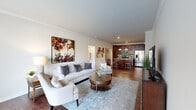 This single-floor residence offers a thoughtfully designed open-concept layout that seamlessly connects the living, dining, and kitchen areas. Rich hardwood flooring flows throughout the main living spaces, complemented by crown molding and recessed lighting that lend a refined finish to the interior.

The living area is bright and spacious, featuring large windows with vertical blinds that invite generous natural light. The kitchen is a standout feature, showcasing rich dark cabinetry, granite countertops, a tile backsplash, stainless steel appliances, and a large island with pendant lighting and bar seating—ideal for both cooking and casual dining.

The bedroom is a comfortable retreat with plush carpeting, a natural light-filled window dressed with striped curtains, and access to a walk-in closet equipped with built-in wire shelving. The en-suite bathroom features a dual-sink granite vanity with dark cabinetry and tile flooring, with a direct passage to the walk-in closet for added convenience.

A dedicated home office nook provides a quiet workspace, while the in-unit laundry room houses a full-size washer and dryer alongside the water heater. The overall ambiance is polished and cohesive throughout.