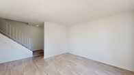Located in Marietta, GA, this two-story, 2-bedroom, 2-bathroom home offers a practical and well-organized layout spread across two floors. The main level features two living areas, both finished with light wood-style flooring that lends a clean, bright aesthetic throughout. One living room is anchored by a pendant light fixture and sliding glass doors that open to a balcony, filling the space with natural light and outdoor views. The kitchen is equipped with warm-toned wood cabinetry, stainless steel appliances including a gas range and over-the-range microwave, and a built-in sink. A louvered bifold closet adds convenient storage adjacent to the kitchen area. A half bathroom on this level features a large mirror and clean, neutral finishes. Upstairs, the upper floor is home to both bedrooms, each carpeted for comfort. The spacious primary bedroom includes a ceiling fan and direct access to a generous walk-in closet outfitted with wire shelving on three walls. The second bedroom features wide louvered bifold closet doors offering ample storage. A full bathroom on this level includes a tiled tub-shower combination and wood-style flooring. A hallway connects the upper-level rooms, completing the home's functional two-floor design.