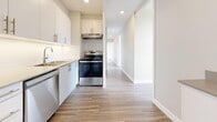 Located at 6020 Bathurst Street in North York, Toronto, this well-appointed 3-bedroom, 2-bathroom unit offers a thoughtfully designed single-floor layout. Light-toned laminate flooring flows consistently throughout the space, complementing the clean, neutral palette of the walls and trim.

The living and dining areas benefit from expansive floor-to-ceiling windows that fill the rooms with abundant natural light and frame open city views of the surrounding Toronto skyline. Baseboard heating units run along the window walls, ensuring year-round comfort.

The kitchen is outfitted with white cabinetry featuring brushed metal hardware, stone-toned countertops, and stainless steel appliances including a refrigerator, electric range with overhead hood, and dishwasher. A bright hallway connects the kitchen to the rest of the unit.

The spacious primary bedroom offers generous proportions and large windows with outdoor views, while the additional bedrooms are well-sized and include built-in sliding-door closets. A dedicated closet provides additional storage.

Both bathrooms are finished with light tile flooring, white cabinetry with brushed metal hardware, and neutral countertops, presenting a clean and modern aesthetic. Recessed lighting in the hallway and kitchen adds a polished finishing touch throughout this bright, move-in ready unit.