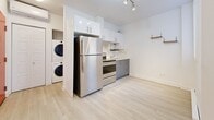 Located at 2238 Rue du Souvenir in Montréal, this efficiently designed one-bedroom, one-bathroom unit offers a thoughtfully organized layout across a single floor. The interior is finished with light hardwood-style flooring and crisp white walls throughout, creating a clean, bright atmosphere that maximizes the sense of space.

The kitchen is a functional highlight, featuring stainless steel appliances including a full-size refrigerator and electric range, sleek two-tone cabinetry with white upper cabinets and grey lower cabinets, and a track lighting system overhead. A stacked washer and dryer unit is conveniently integrated into the kitchen area, adding practical in-unit laundry access.

The living area flows openly from the kitchen and benefits from natural light through a window fitted with a blind. Electric baseboard heating runs along the walls, ensuring year-round comfort. The bedroom is a cozy, well-defined space with its own window that invites natural light and includes baseboard heating as well.

The bathroom is finished with large-format white subway tiles surrounding a full soaking bathtub and shower combination, complemented by a recessed ceiling light for a clean, polished look. The hallway connects all areas of the unit smoothly. Overall, the unit presents a modern, move-in-ready aesthetic well-suited to urban living in Montréal.