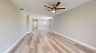 Located at 9623 Cypress Park Way in Boynton Beach, FL, this single-floor, 2-bedroom, 3-bathroom home offers a well-designed layout with a clean, modern aesthetic throughout. Light wood-look flooring flows seamlessly across the living areas and bedrooms, creating a bright and cohesive feel.

The open living room is generously sized, featuring a ceiling fan with a brushed gold finish and sliding glass doors that lead to a private balcony with wrought iron railings, filling the space with natural light and outdoor views. The kitchen is well-appointed with crisp white cabinetry, stainless steel appliances including a range, microwave, dishwasher, and refrigerator, set against light countertops and a window that brings in additional natural light.

Both bedrooms are comfortably sized, each featuring ceiling fans, large windows with vertical blinds, and light-toned flooring. The primary bedroom connects to a dedicated closet and bathroom. The bathrooms are finished with white shaker-style cabinetry, stone-look countertops, and walk-in showers with terrazzo-style tile flooring and brushed gold fixtures. A dedicated laundry area with a water heater rounds out the home's practical amenities, making this a well-equipped and move-in-ready residence.