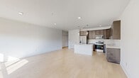 Located at 31601 Gabby Ct in Chesterfield, MI, this thoughtfully designed single-floor home offers 2 bedrooms and 2 bathrooms with a clean, modern aesthetic throughout. Light-toned hardwood flooring flows continuously across the entire living space, creating a cohesive and airy feel.

The heart of the home is a spacious open-concept area that seamlessly integrates the living room, dining room, and kitchen. The kitchen is well-appointed with rich dark-toned cabinetry, a striking marble-style backsplash, a central island with bright white quartz countertops, pendant lighting, and a full suite of stainless steel appliances including a refrigerator, range, microwave, and dishwasher.

The living area is bathed in natural light from large windows that frame outdoor views of greenery, lending the space a bright and welcoming ambiance. Both bedrooms are generously proportioned, featuring the same warm hardwood flooring and large windows that invite ample daylight.

The two bathrooms are finished with dark wood vanity cabinetry and white countertops. One bathroom features a glass-enclosed walk-in shower, while the second includes a full soaking tub. A dedicated utility room houses a stacked washer and dryer. Six closets throughout the home provide exceptional storage. Recessed lighting and clean white walls complete the modern, move-in-ready presentation.