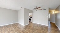 Located at 305 Glades Cir in Largo, FL, this single-floor, 3-bedroom, 2-bathroom home offers a well-organized layout designed for comfortable everyday living. Wood-look plank flooring runs throughout the home, complemented by neutral gray walls and textured ceilings, creating a clean and cohesive aesthetic.

The kitchen is a standout feature, showcasing white shaker cabinetry, granite countertops, a gray subway tile backsplash, and a full suite of stainless steel appliances including a refrigerator, dishwasher, and range. A window above the sink brings in natural light, enhancing the bright and functional workspace.

The living area is open and inviting, featuring a ceiling fan, sliding glass door with vertical blinds leading to an outdoor area, and an entry door that allows natural light to filter through. The space feels airy and versatile.

Each bedroom offers wood-look flooring, natural light from windows with blinds, and neutral tones. The primary bedroom includes a double closet and is conveniently situated near an in-unit stacked washer and dryer.

Both bathrooms are finished with white vanity cabinetry and granite countertops. One bathroom includes a tub-shower combo, while the other features a single vanity with a large mirror. Together, these spaces reflect a consistent, updated design throughout the home.