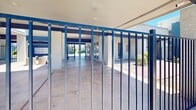 Located at 8028 S Central Ave in Phoenix, Arizona, this residential community is designed to take full advantage of the region's sunny desert climate. The property's exterior showcases a bold two-tone façade of white stucco and deep blue accents, lending the buildings a modern, eye-catching appearance. Multiple units feature private balconies that overlook the shared outdoor spaces, providing residents with personal outdoor retreats.

At the heart of the community lies a generously sized outdoor swimming pool surrounded by a wide concrete deck, ideal for relaxing in the abundant Arizona sunshine. Towering palm trees frame the pool area, enhancing the resort-like atmosphere. A spa or wading area is also present adjacent to the main pool, adding an additional amenity for residents. The pool enclosure is secured with iron fencing, ensuring a safe and private environment.

Entry to the community is controlled through a gated access point featuring sturdy metal railings and a covered passage supported by concrete columns painted in the property's signature blue. Desert-adapted landscaping, including shrubs and gravel groundcover, surrounds the buildings, complementing the arid Phoenix environment while minimizing water usage. The overall layout and design reflect a community built for comfortable, sun-filled living in the heart of South Phoenix.