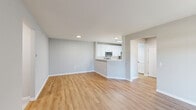 Located at 2800 New Brunswick Ave in Piscataway, NJ, this single-floor, 3-bedroom, 2-bathroom home offers a well-designed layout with modern finishes throughout. The open-concept kitchen and living area forms the heart of the home, featuring warm wood-look flooring, a peninsula with a breakfast bar, white shaker cabinets, marble-style countertops, a classic subway tile backsplash, and stainless steel appliances including a gas range, microwave, and dishwasher. The living room extends from the kitchen and is bathed in natural light through a large sliding glass door with vertical blinds. Two connecting hallways guide residents through the home with ease. The generously sized primary bedroom includes plush carpeting, a walk-in closet, and a private en-suite bathroom with a tiled shower. The second bathroom features tile flooring, a white vanity with a marble-style countertop, black hardware accents, and a tub-shower combination. A dedicated laundry room houses a full-size washer and dryer with overhead shelving for added storage. Neutral gray-toned walls, crisp white trim, and consistent wood-look flooring in the main areas tie the home together in a clean, contemporary aesthetic.