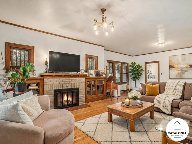 Sala de estar parcialmente amueblada que incluye sofás, TV y mesas. - 2025 8th Ave