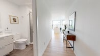 Located in the heart of Montréal, this contemporary 3-bedroom, 4-bathroom residence offers a refined urban living experience defined by clean lines, a bright neutral palette, and exceptional views of the city skyline and Mont-Royal. Light hardwood flooring flows throughout the open-concept layout, anchoring a cohesive and modern aesthetic.

The living room is spacious and airy, bathed in natural light with a minimalist design that creates a calm, welcoming atmosphere. The adjacent kitchen is sleek and well-appointed, featuring white cabinetry, stainless steel appliances, a glass tile backsplash, and a central island with quartz countertops — all framed by a large window offering sweeping panoramic views. The dining area benefits from the same stunning outlook, with floor-to-ceiling windows that bring the cityscape indoors.

Each of the three bedrooms is generously proportioned, with large windows that fill the rooms with natural light and offer views of the surrounding urban landscape. The primary bedroom includes built-in closet storage and its own dedicated bathroom. The four bathrooms throughout are finished with large-format tile, glass-enclosed showers, and modern fixtures. A dedicated closet provides additional storage. The overall ambiance is polished, bright, and thoughtfully designed for contemporary city living.