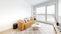 Located at 256 Boulevard St-Raymond in Gatineau, Quebec, this well-designed 2-bedroom, 1-bathroom unit offers a thoughtfully organized layout across a single floor. The modern aesthetic is defined by clean lines, bright white walls, and light hardwood flooring that flows throughout the main living areas.

The open-concept kitchen is a standout feature, showcasing sleek white cabinetry, a subway tile backsplash, stainless steel appliances including a dishwasher and oven range, and a light wood peninsula with a white countertop and bar seating — ideal for casual dining or entertaining. Pendant lighting adds a refined touch overhead.

The living room is bathed in natural light through large floor-to-ceiling windows that open to a balcony, offering expansive outdoor views of the surrounding landscape. The space feels airy and inviting, with clean architectural lines throughout.

The primary bedroom features large windows with neighborhood views, light carpeting, and ample room for a full bedroom suite. The second bedroom is compact yet functional, with light flooring and a calm, neutral palette.

The full bathroom is well-appointed with a glass-enclosed shower, in-unit washer, and light tile flooring, offering both practicality and comfort. A dedicated closet completes the layout, maximizing storage within the space.