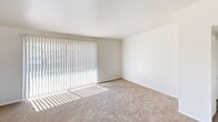 Located at 358 E Roeser Rd in Phoenix, Arizona, this single-floor, three-bedroom, one-bathroom home offers a practical and functional layout across a compact footprint. The interior is characterized by white-painted brick accent walls throughout several rooms, lending a distinct, textured aesthetic to the space.

The three bedrooms are carpeted in neutral tones and receive natural light through windows fitted with vertical blinds. The spacious primary bedroom features white-painted brick walls and large sliding glass doors that flood the room with sunlight. Additional bedrooms also display the signature brick wall detailing, with windows offering outdoor views. At least one bedroom includes a built-in closet for storage.

The kitchen is outfitted with warm-toned wood cabinetry, light countertops, a double-basin sink, and white appliances including a refrigerator and electric range. Wood-look flooring ties the kitchen together and extends into the bathroom, creating a cohesive flow between these areas.

The bathroom features a full tub-shower combination with a marble-style large-format tile surround, a window for natural ventilation and light, and a clean white vanity. Two hallways connect the rooms throughout the home, contributing to an efficient and straightforward floor plan suited for comfortable everyday living.