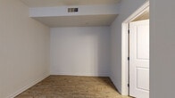 Located at 6851 S Gaylord St in Centennial, Colorado, this efficiently designed single-floor unit offers a well-organized layout encompassing a combined kitchen and living area, one full bathroom, and a closet. The open-concept kitchen is a standout feature, equipped with stainless steel appliances including a side-by-side refrigerator with ice maker, an electric range, and a built-in microwave. Warm maple cabinetry extends to the ceiling for ample storage, while dark granite countertops provide a striking contrast. A peninsula with additional counter space and pendant lighting adds both functionality and style to the kitchen. Wood-look flooring flows consistently throughout the unit, lending warmth and cohesion to the space. The living area benefits from large windows fitted with vertical blinds, allowing abundant natural light and views of the surrounding neighborhood. Ceiling-height accents and recessed lighting enhance the sense of openness. The bathroom is clean and functional, featuring a toilet with overhead wood-toned cabinetry for extra storage. A dedicated closet provides convenient organization space. A stacked washer and dryer unit is included, adding practical in-unit laundry convenience. The overall aesthetic is neutral and modern, with crisp white walls and clean finishes throughout.