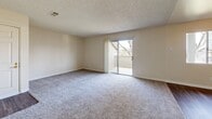 Located at 1301 Richland Ave in Modesto, CA, this single-floor, 2-bedroom, 2-bathroom residence offers a functional and comfortable layout. The entrance opens to a carpeted living area featuring a sliding glass door that leads to a private balcony overlooking a landscaped yard and mature trees, bringing in natural light and outdoor views.

The galley-style kitchen is open to the living space and features rich dark wood cabinetry lining both walls, light countertops, a built-in sink, white appliances including a refrigerator and electric range, and durable hardwood-style vinyl flooring. Ample upper and lower cabinetry provides generous storage throughout.

Both bedrooms are carpeted and feature neutral walls with windows that allow in natural light. The primary bedroom includes a mirrored sliding closet, while the second bedroom offers a similarly bright and open feel with an additional closet. A textured ceiling is present throughout much of the unit.

The two bathrooms are clean and functional, each featuring a full tub/shower combo with white surround, a toilet, and hardwood-style flooring. One bathroom includes a dark wood vanity with a countertop sink for added style. Overall, the residence presents a straightforward, well-maintained living environment in a residential Modesto neighborhood.