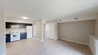 Located at 2 Colony Blvd in Wilmington, Delaware, this one-bedroom, one-bathroom residence offers a thoughtfully arranged single-floor layout. The combined kitchen and living area serves as the heart of the home, with light wood-style flooring running throughout. The kitchen is equipped with dark navy cabinetry, light countertops, a white electric range, and a full-size refrigerator, providing ample storage and functionality. The living room is bright and open, featuring a built-in shelving unit and a sliding glass door that opens to an outdoor patio, inviting natural light and outdoor views into the space. A hallway connects the main living areas to the private quarters. The bedroom is a comfortable, carpeted retreat with a double-door closet and a window that brings in additional natural light. Neutral gray tones on the walls throughout the residence create a clean, cohesive aesthetic. The bathroom features a tiled shower-tub combination with a curtain rod. A hallway with additional storage completes this efficiently designed, move-in-ready home.
